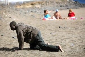 Un inmigrante a los posibles arrastra en la playa después de su llegada en un barco improvisado en la playa de Gran Tarajal, en la isla de España canaria de Fuerteventura en esta foto de archivo del 05 de mayo 2006. Juan Medina: